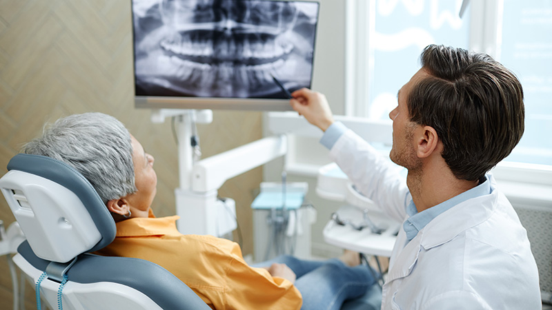 dentist viewing x-ray with patient in dental chair